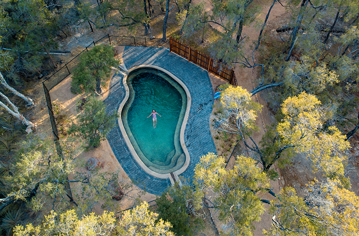 an aerial view of a pool with a person floating in it