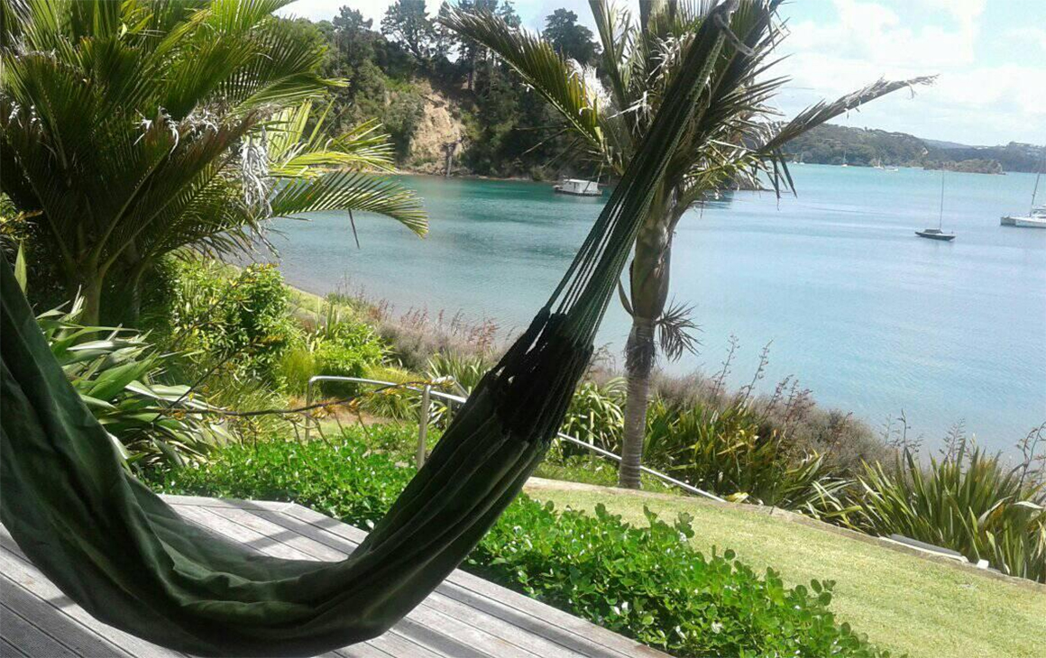 A hammock swings on the verandah at Te Hine Ruru Retreat, one of New Zealand's best retreats.