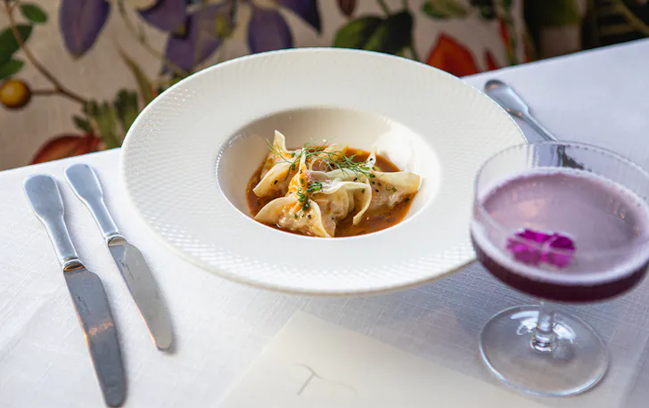 a bowl of dumplings and a cocktail