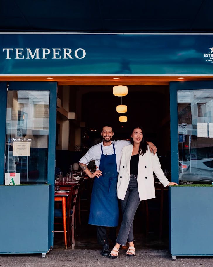 Owners Fabio & Tiffany of Temepero pose for a photo in the entrance of the blue restaurant.