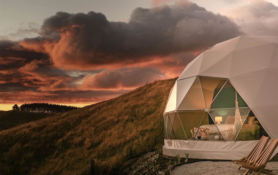 A view of the outside of Te Tuhi Dome near Taupo under a fiery red sky.