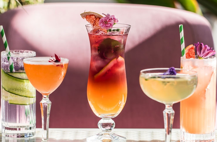 A lineup of brightly coloured cocktails. 