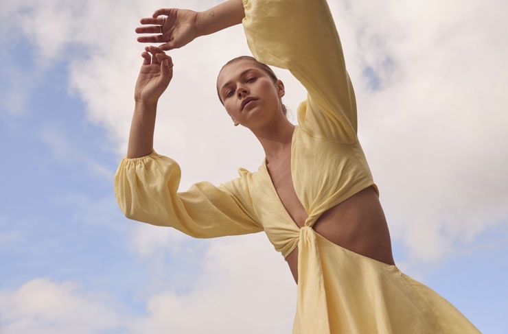 A model wearing a pale yellow LOVER dress with cut outs