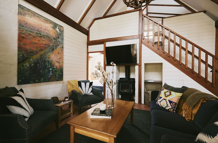 A ranch-inspired living room with timber accents and plush blue couches. 