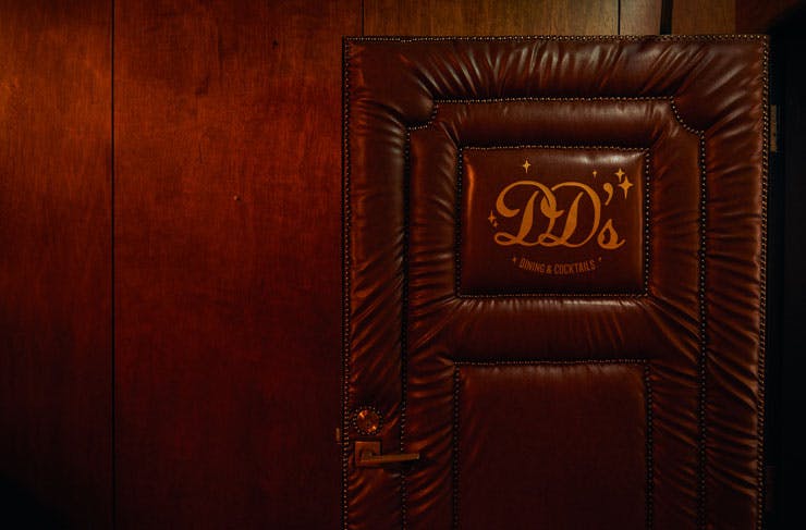 A brown leather padded door with the letters 
