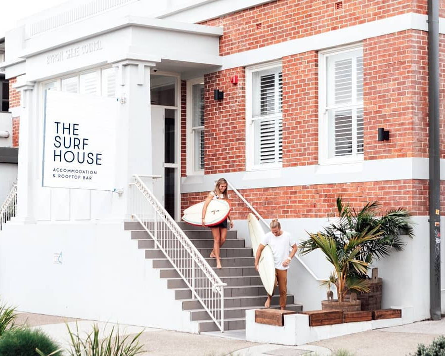 two people walking in front of The Surf House in Byron