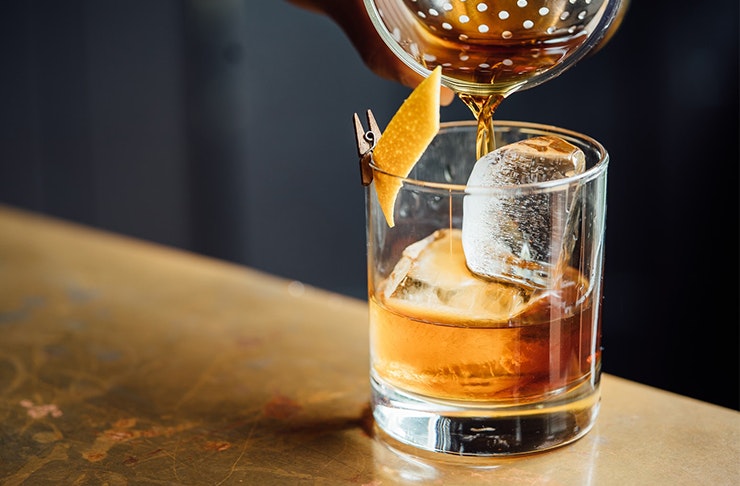 someone pouring whiskey in a glass