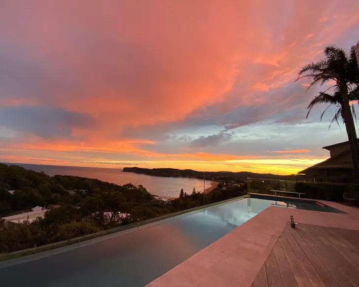 A view across the pool at sunset at The Vue Airbnb some of the best Central Coast accommodation