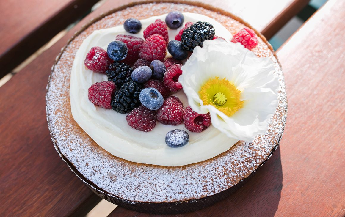 A cake topped with flowers and berries