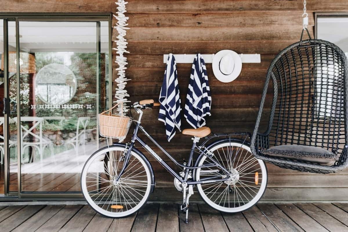 a bike and a hanging egg chair in front of.a wall