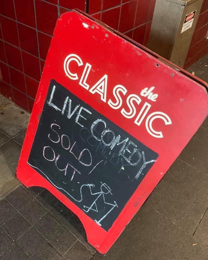 A red street sandwich board sign for The Classic reads 'Live Comedy Sold Out!' in chalk.