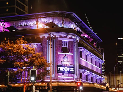 Facade of The Fox Hotel lit up with purple lights
