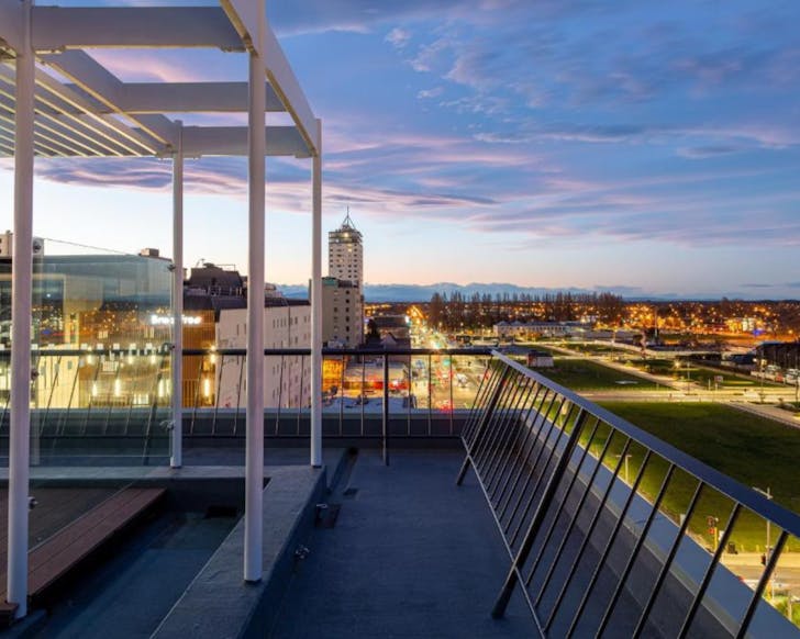 A rooftop sunset view of Christchurch City on top of The Muse Hotel.