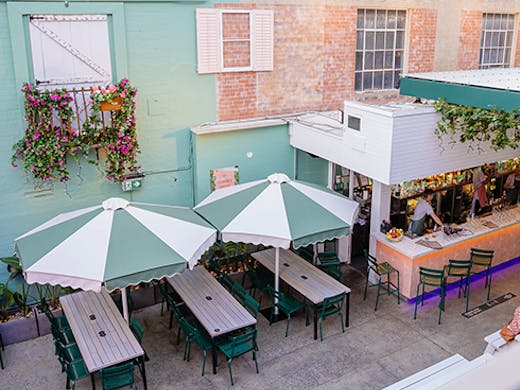 an outdoor bar area with striped umbrellas