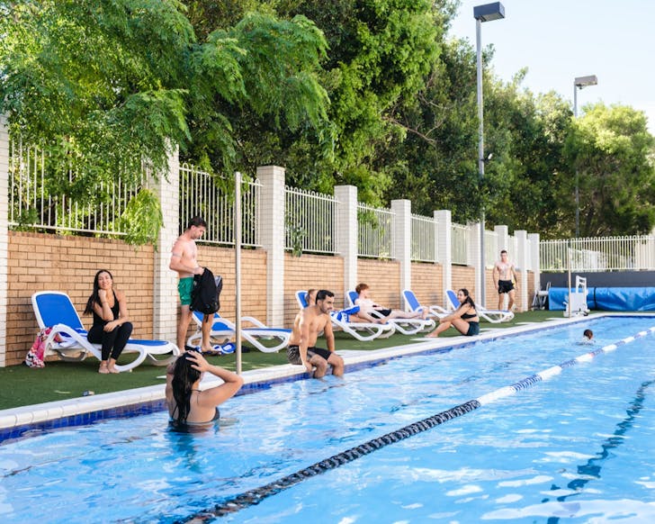 People sitting around the outdoor magnesium pool at The Strand gym in Townsville. 