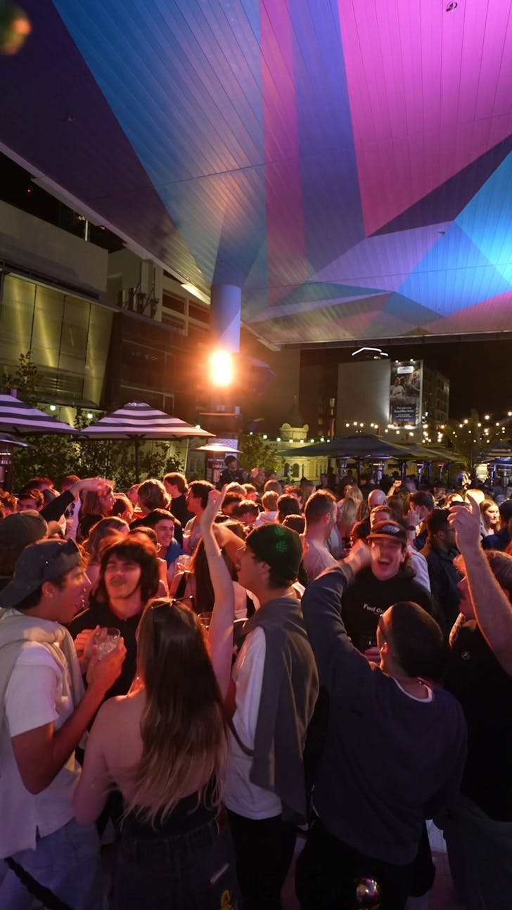 âCrowd enjoying a lively rooftop party at The Aviary in Perth under colourful lights. The scene captures the cityâs energetic nightlife and social vibe with drinks, music, and friends celebrating outdoors.â