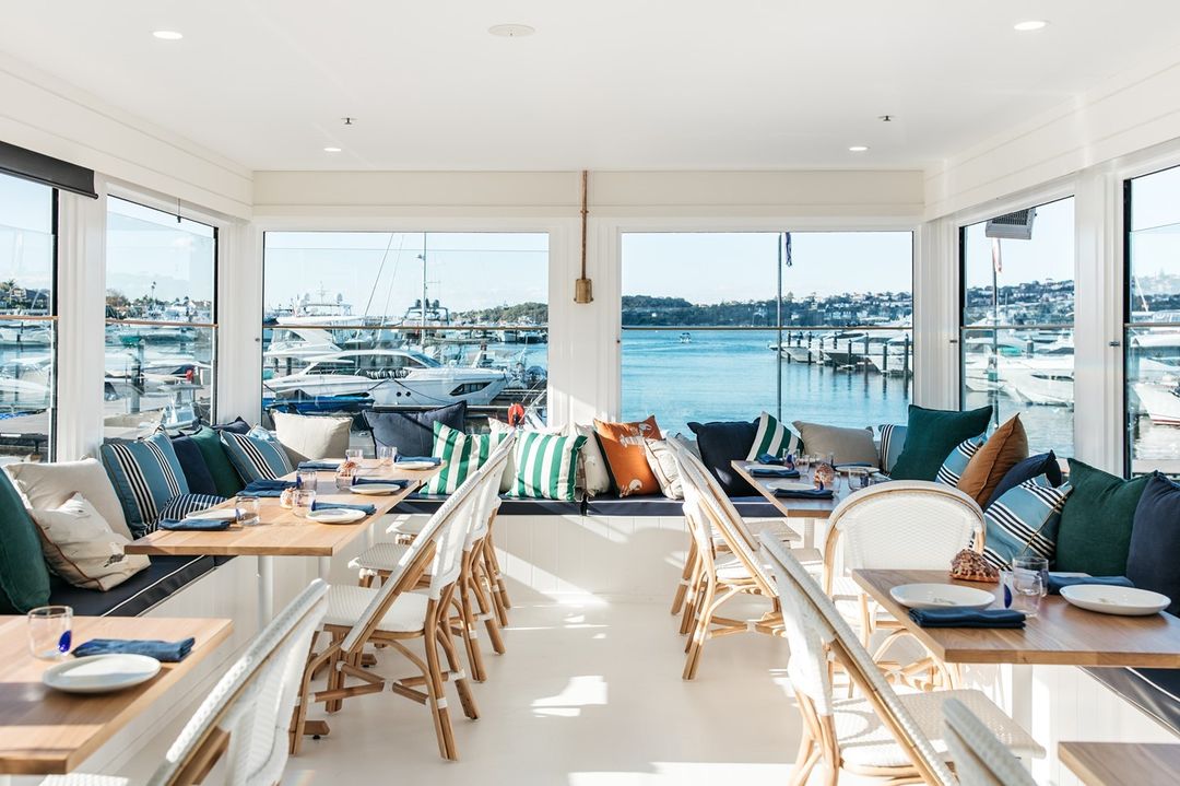 the interior of a beautiful restaurant overlooking a marina