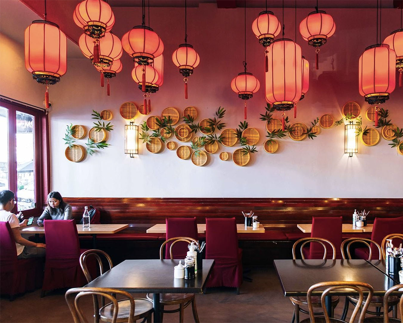 The interior at The Chilli House shows gorgeous red lamps and seats.