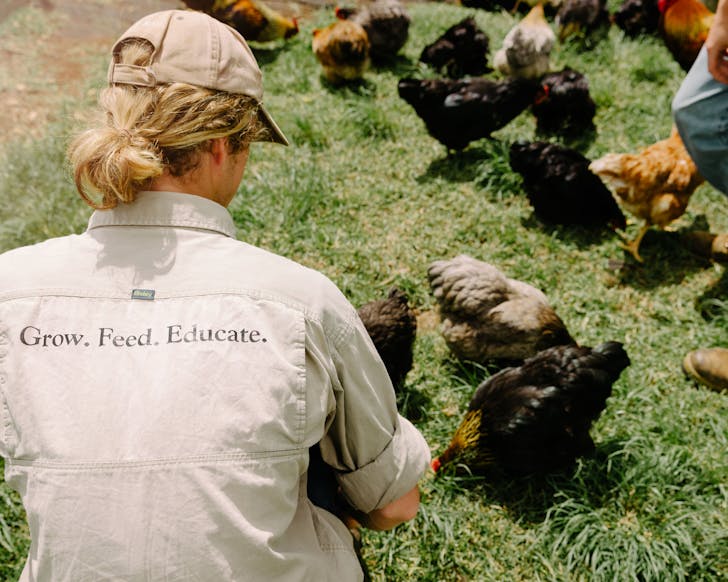 A staff member wears a grow, feed, educate shirt at The Farm In Byron Bay