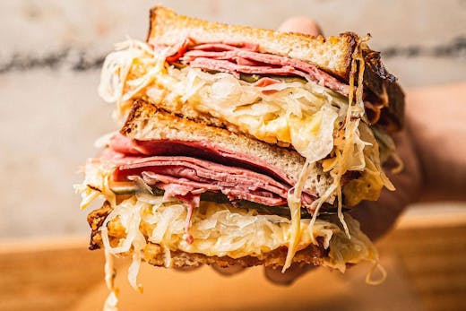 A reuben sandwich sliced in half from Theo's Deli.