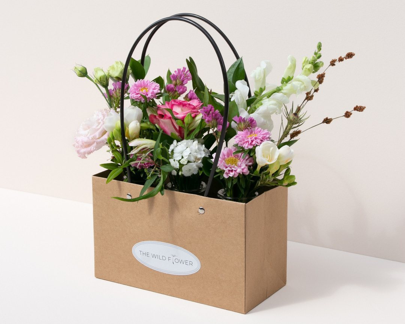 A pretty bunch from The Wild Flower is displayed in their chic paper box packaging