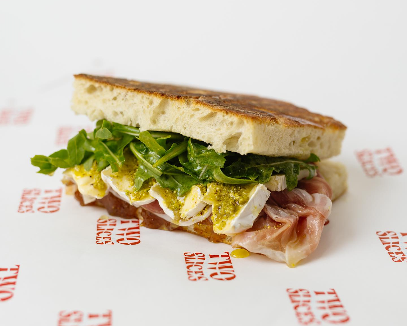 Two Slices focaccia panini loaded with prosciutto and cheese 