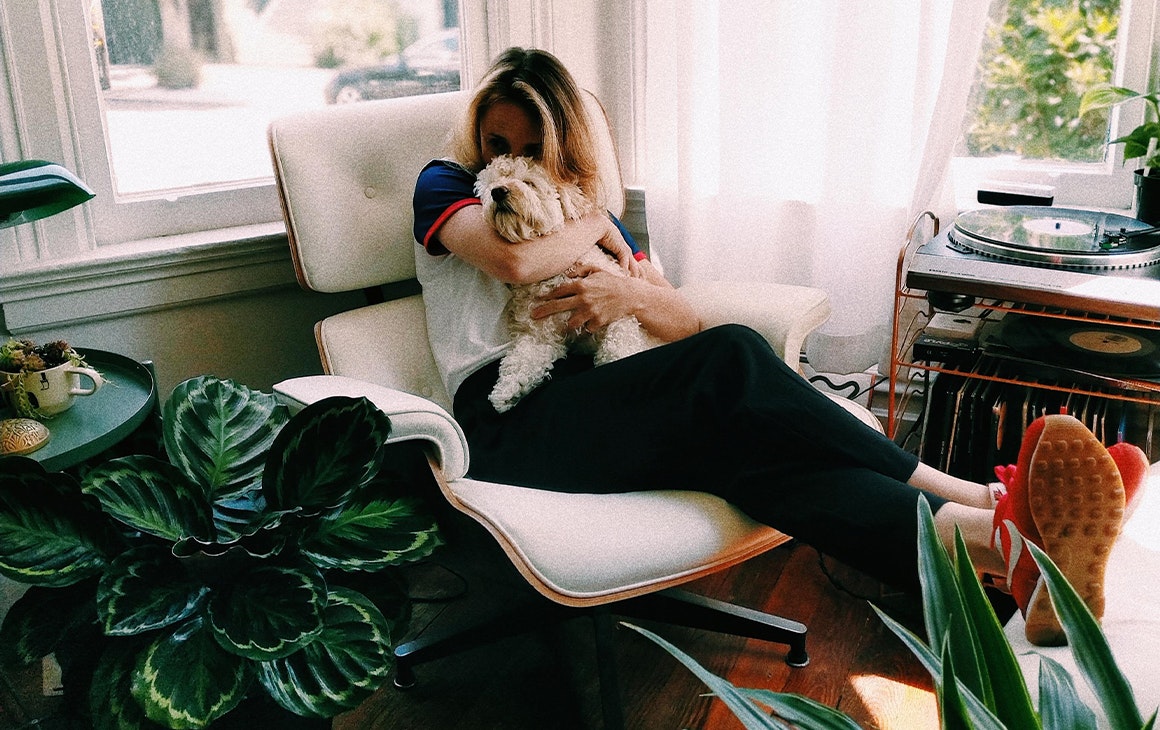 woman cuddling a puppy sitting on a lounge chair in her living room