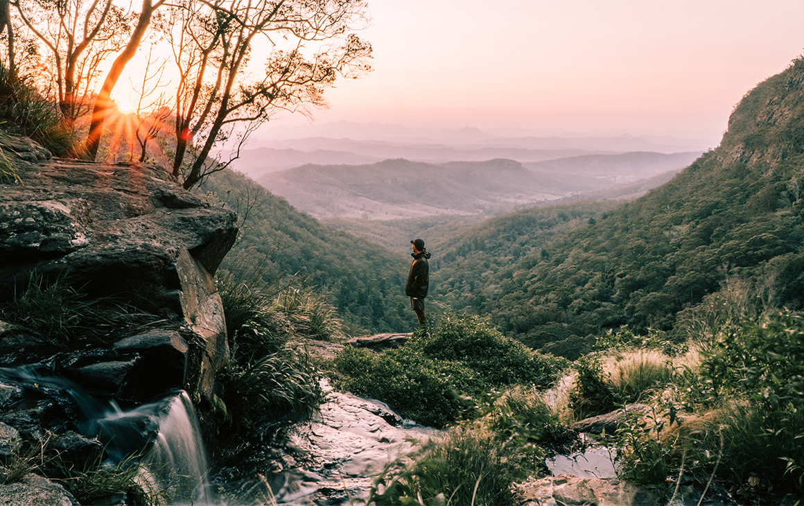 person standing on a waterfall in the scenic rim