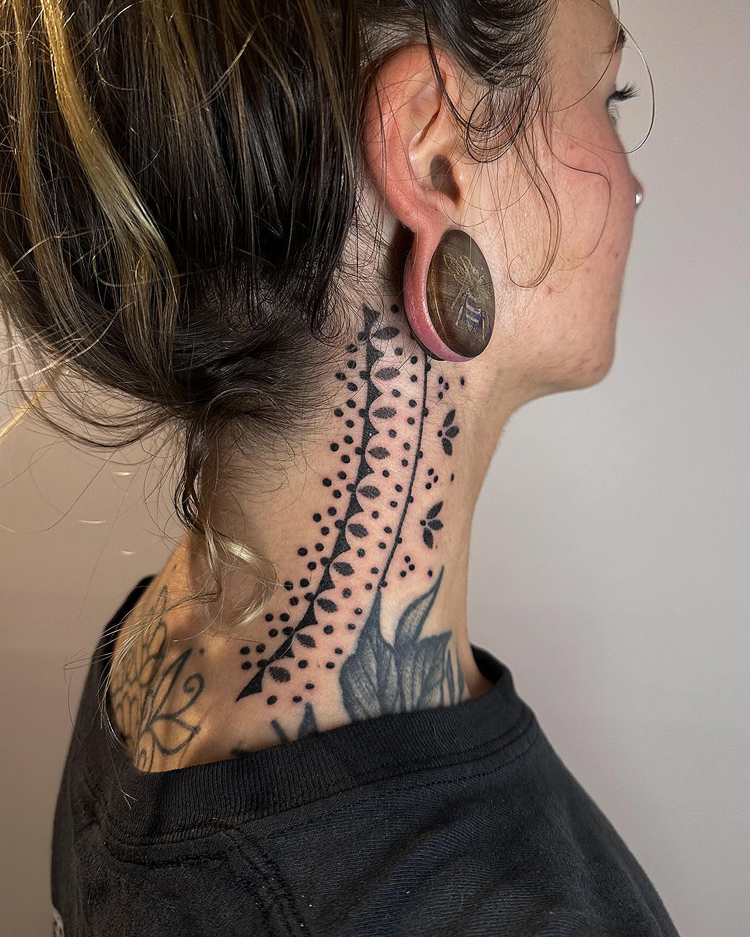 Someone with lovely tattoos on their neck from three dice tattoo.