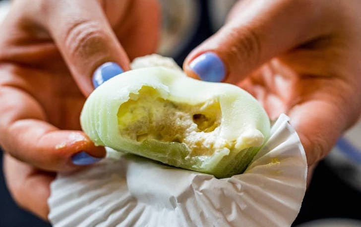 person holding a piece of mochi