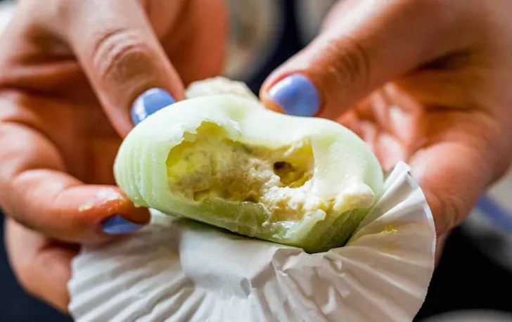 person holding a piece of mochi