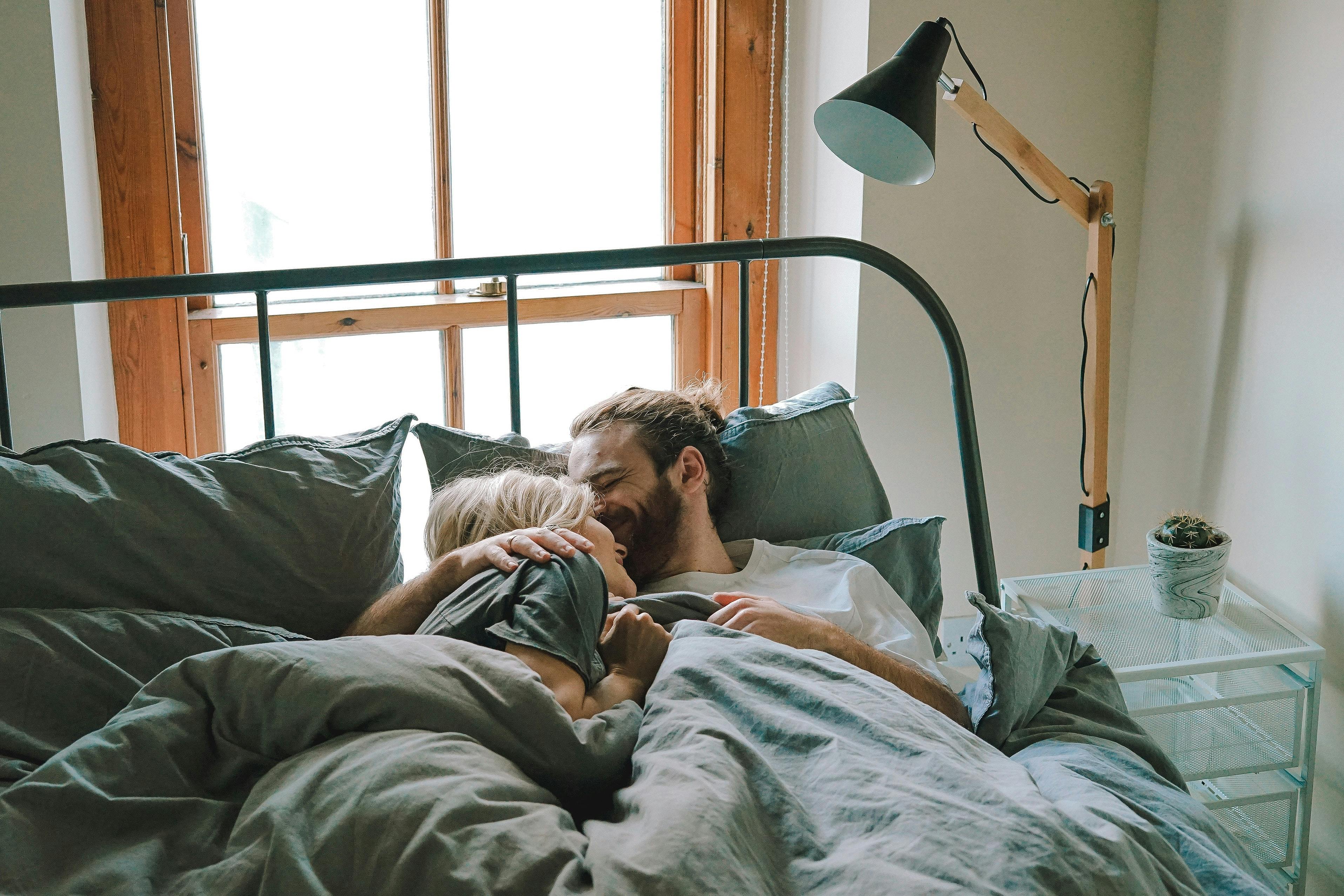 A couple embracing in bed.