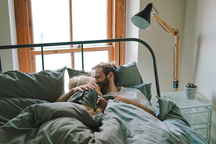 A couple embracing in bed.