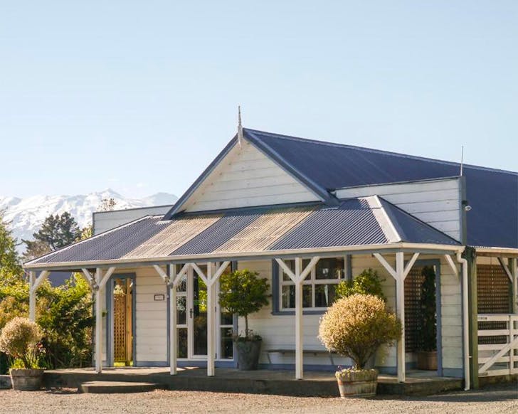 The Tongariro Crossing Lodge with snow-capped mountains seen behind.