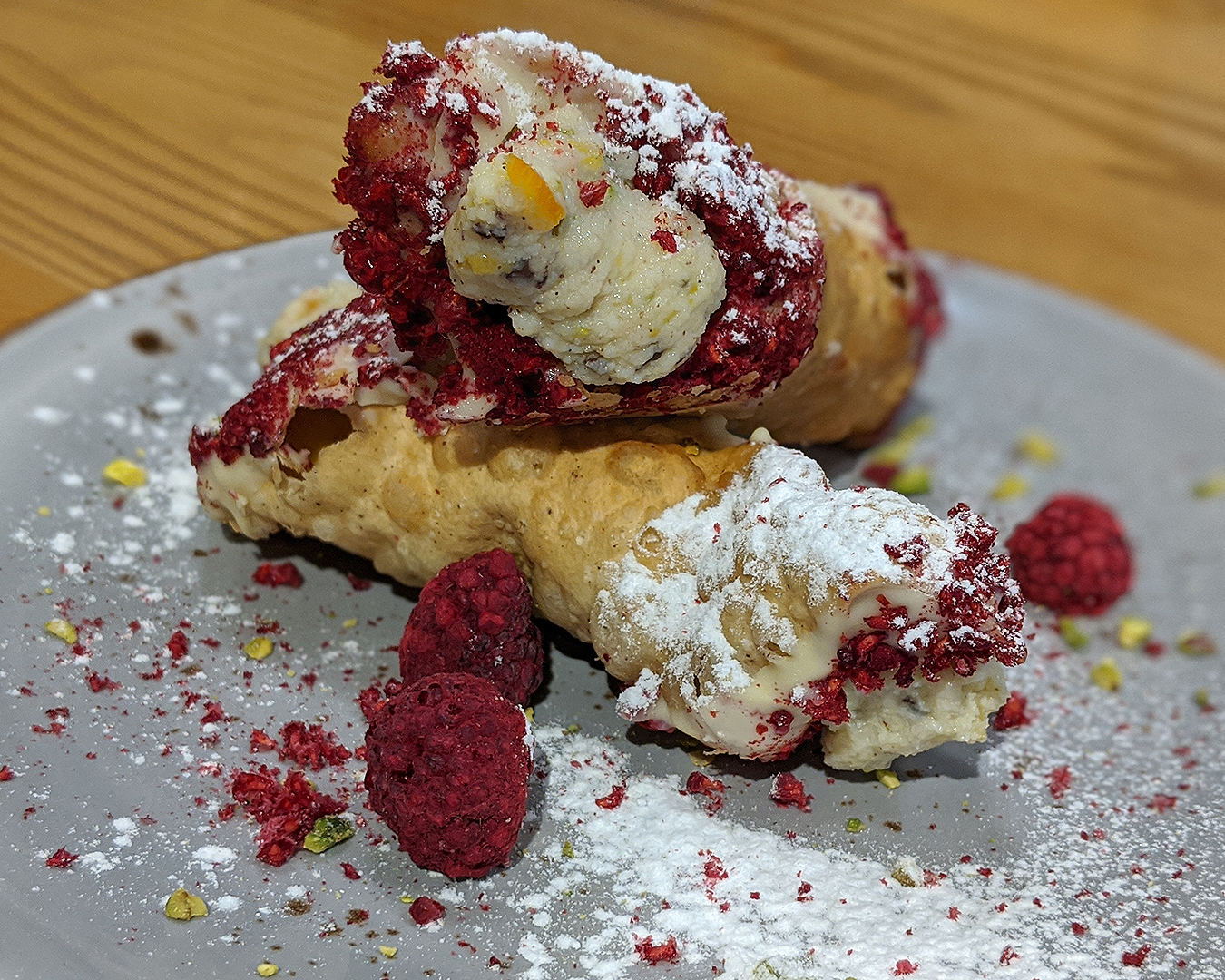 The cannoli at Toto, in the CBD. Sitting on a plate beautifully dusted with icing sugar and covered with rapberries.