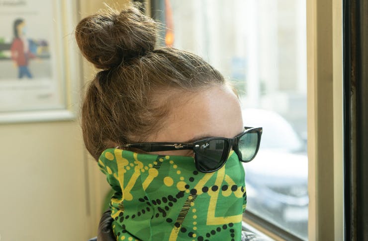 A woman wearing a face mask with the same print as the seats on Melbourne's trams.