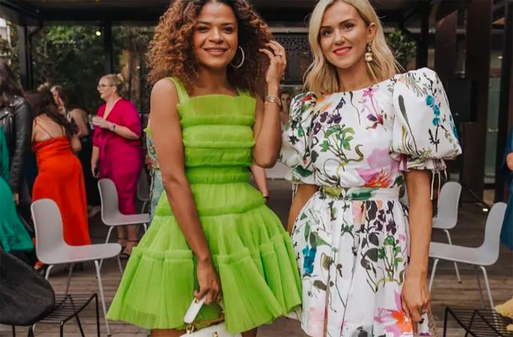 Two women pose in their dresses hired from Treasureboxx, one of the best dress hire shops in NZ.
