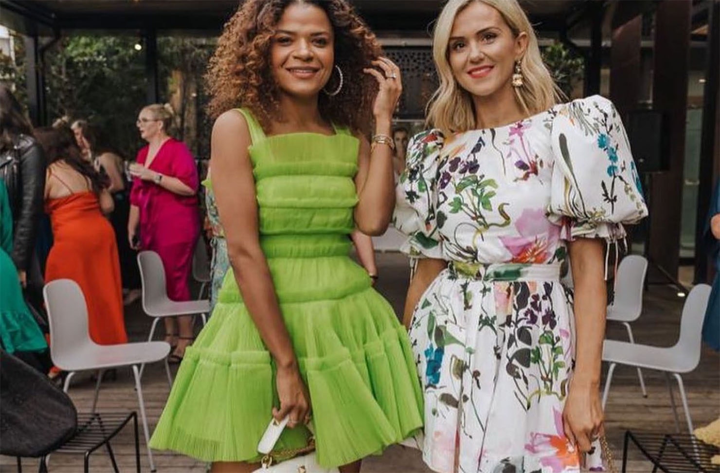 Two women pose in their dresses hired from Treasureboxx, one of the best dress hire shops in NZ.