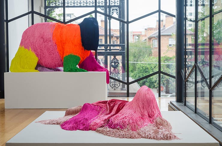 Several tinsel-covered sculptures in a sunlit gallery.