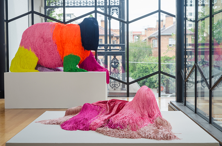 Several tinsel-covered sculptures in a sunlit gallery.