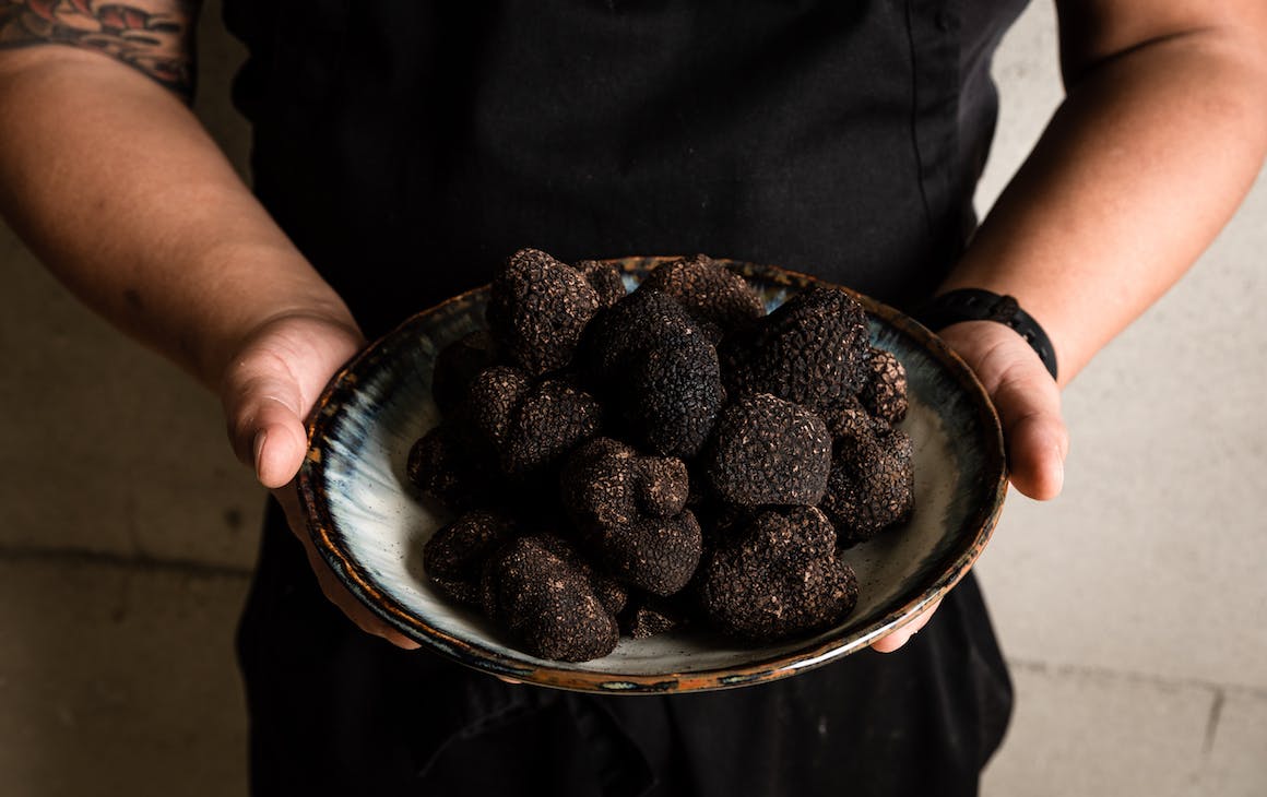 chef holds bowl full of truffles