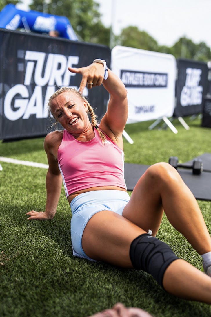 Someone rests on the grass and poses for the camera after a hard Turf Games workout.