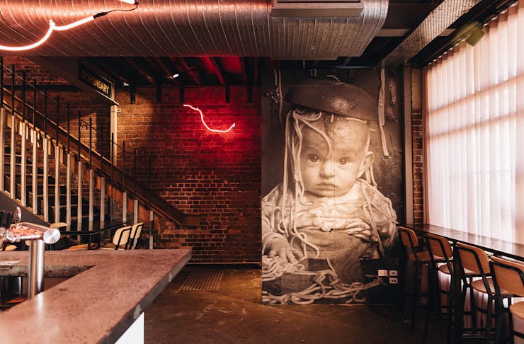 a wall with a poster of a baby with spaghetti on their head