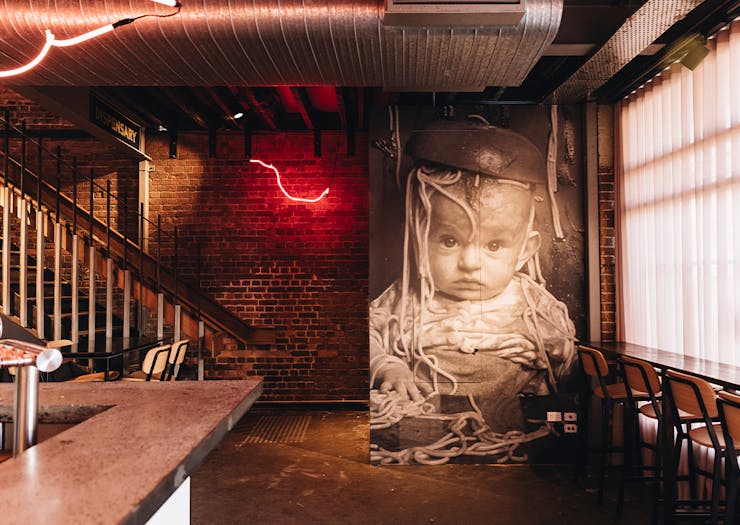 a wall with a poster of a baby with spaghetti on their head