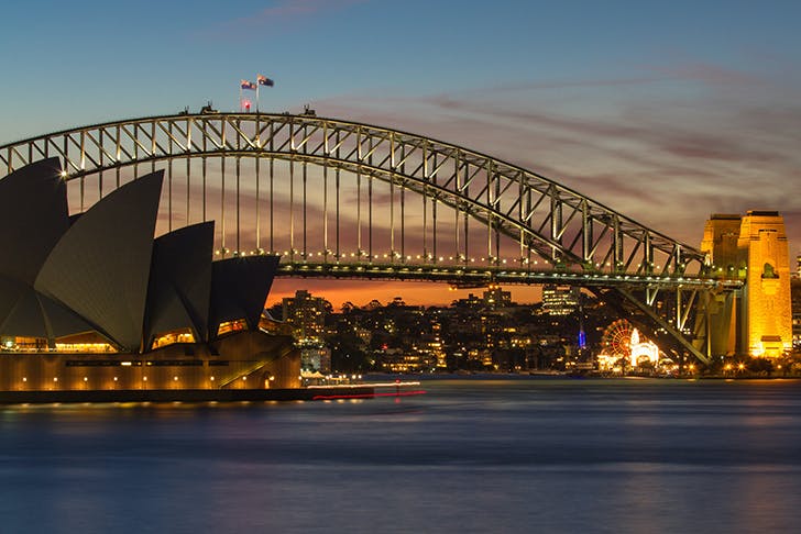 a nighttime shot of the sydney harbour bridge and opera house