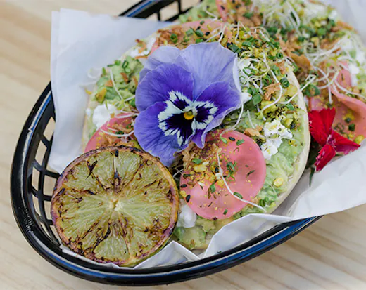 a bagel topped with avocado and feta