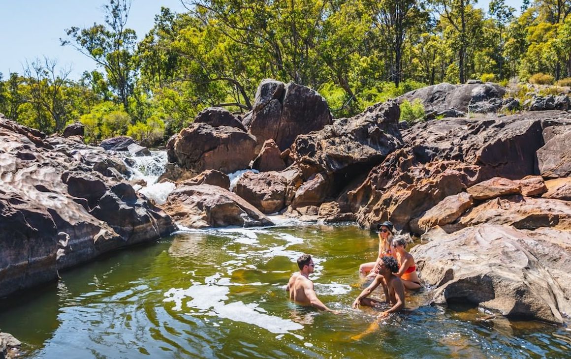 Four friends swimming in a natural pool in Dwellingup