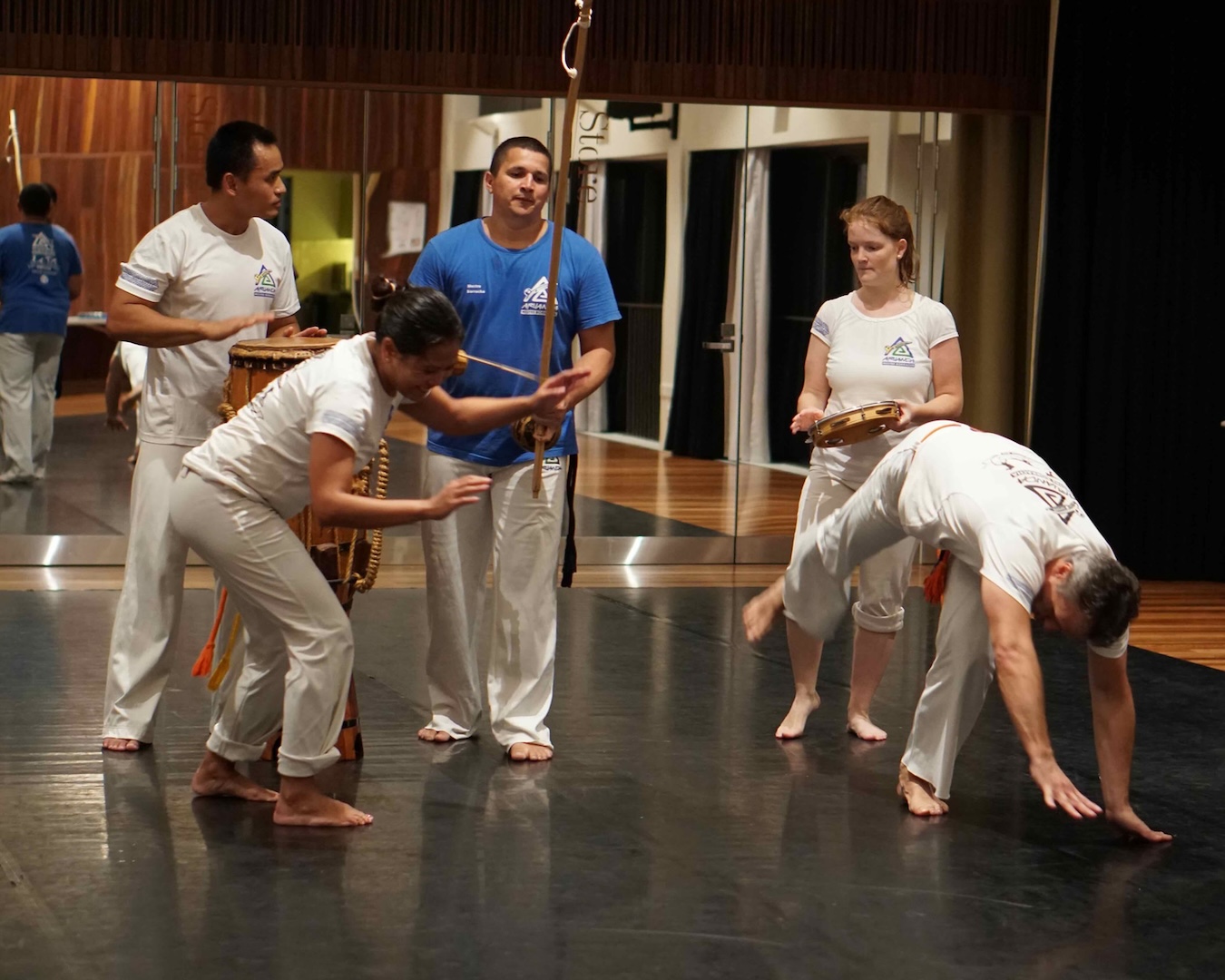 people performing capoeira tumbles and music