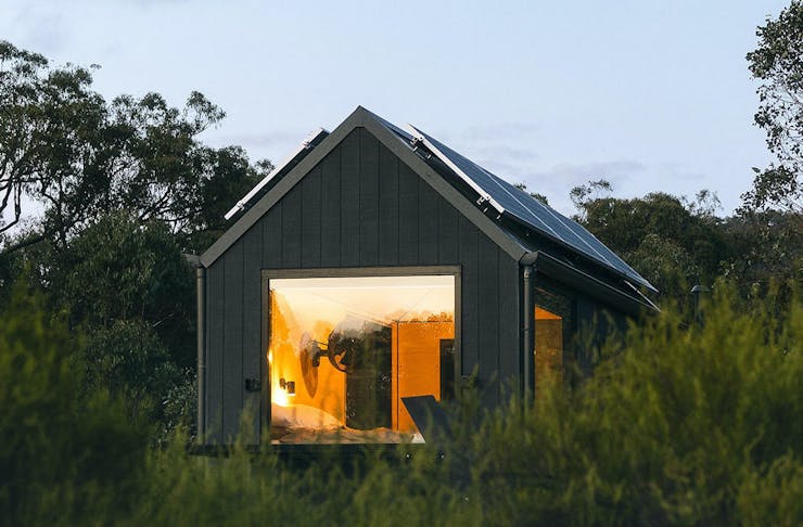 Unyoked's Louka cabin set amongst bushes and pine trees in the Central Gippsland mountains.