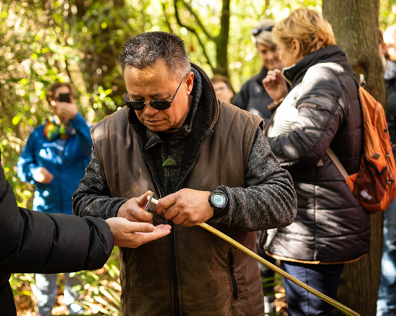 A man teaches foraging in the forest.